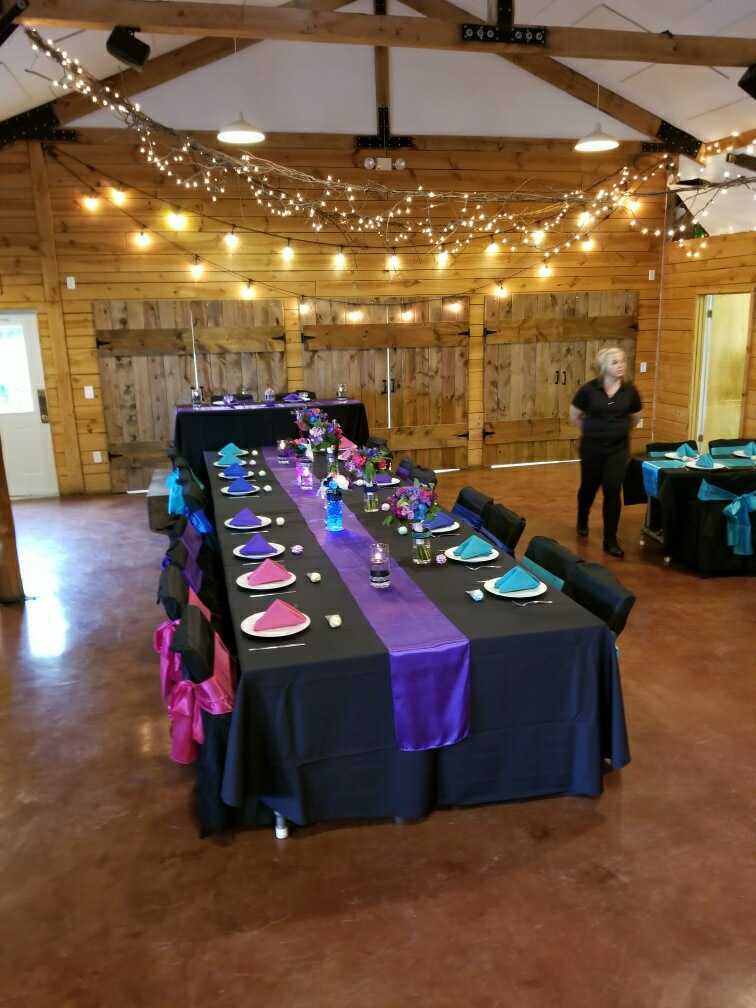 Rustic barn reception with string lights and jewel-tone linens